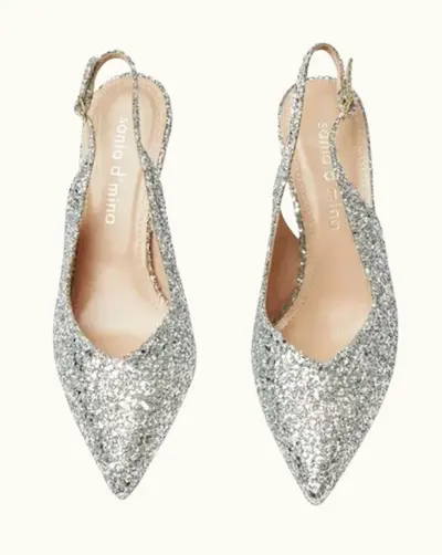Silvriga skor med öppen häl, sling-nbacks och spetsig tå. Skona är silverfärgade med glitter på. Från Sania Dmina.