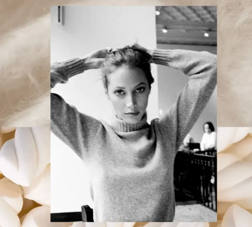 Svartvit bild på Christy Turlington i en stickad tröja. Bakgrundskollage med beige cashmeretyg och ljusa marshmallows.