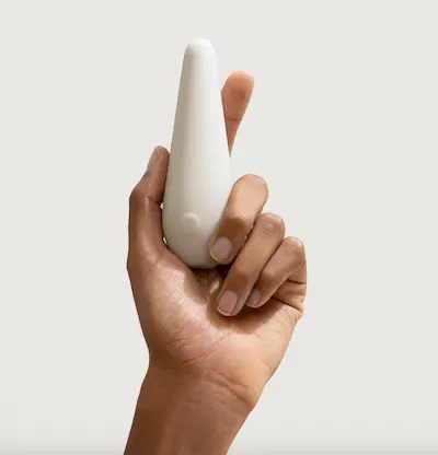 Hand som håller en liten, vit vibrator.