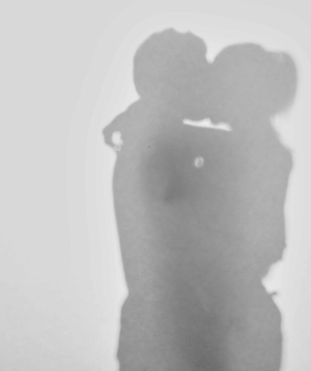 Ett par som omfamnar varandra, suddig bild i svartvitt.