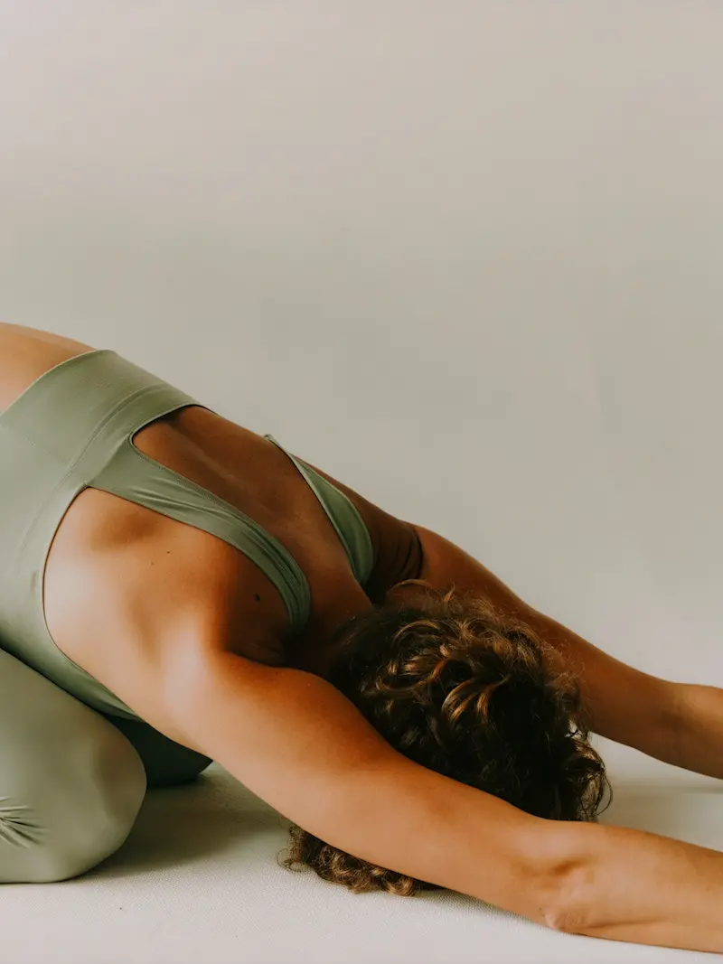 Kvinna som stretchar i gröna träningskläder