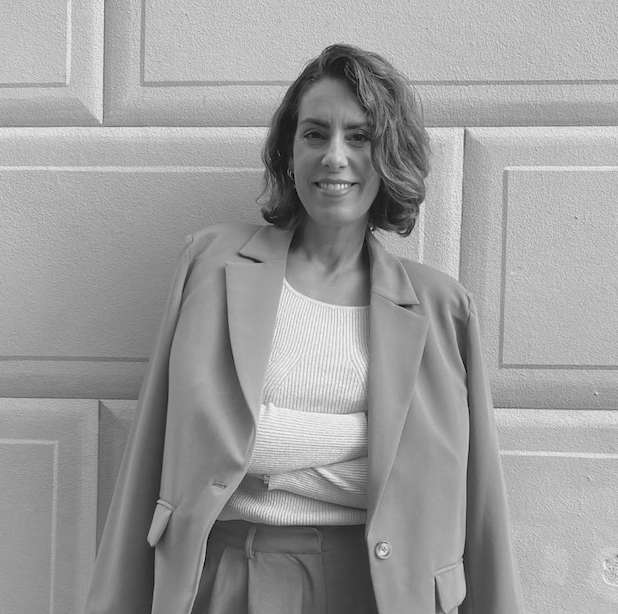 Bild på Nina Campioni som berättar om hur hon kom i klimakteriet vid 39 årsålder. Hon har kort, vågigt brunt hår. Hon ler och har armarna i kors och en kavaj över axlarna.