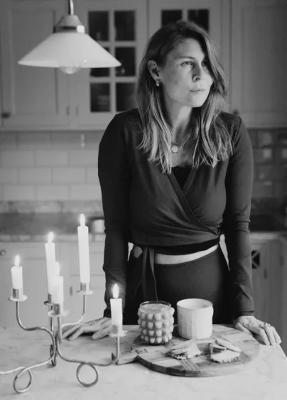 Kreatören och entreprenören Kristin Lagerkvist, även kallad Krickelin fotograferad hemma i sitt kök, ståendes vid ett bord. Hon tittar åt sidan, har utsläppt hår till axlarna och en två delat sett på sig med v-ringning och knyt i midjan.