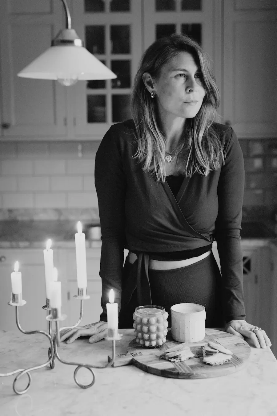 Kreatören och entreprenören Kristin Lagerkvist, även kallad Krickelin fotograferad hemma i sitt kök, ståendes vid ett bord. Hon tittar åt sidan, har utsläppt hår till axlarna och en två delat sett på sig med v-ringning och knyt i midjan.