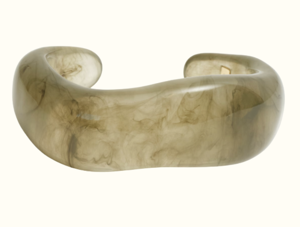 Armband i transparent material. Hård cuff i vågform, melerad i olika grå och beige nyanser.
